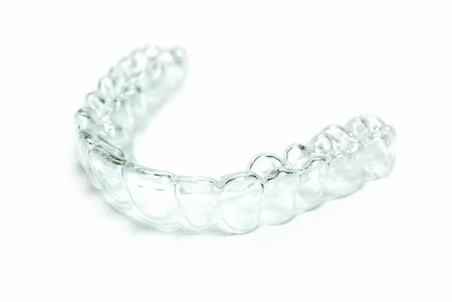 A clear aligner resting on a surface